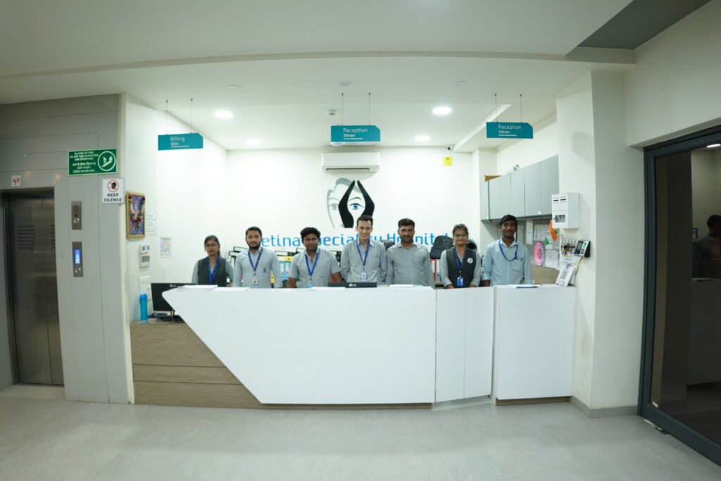 A group of people, including a retina specialist doctor, standing in front of a reception desk in a medical office.